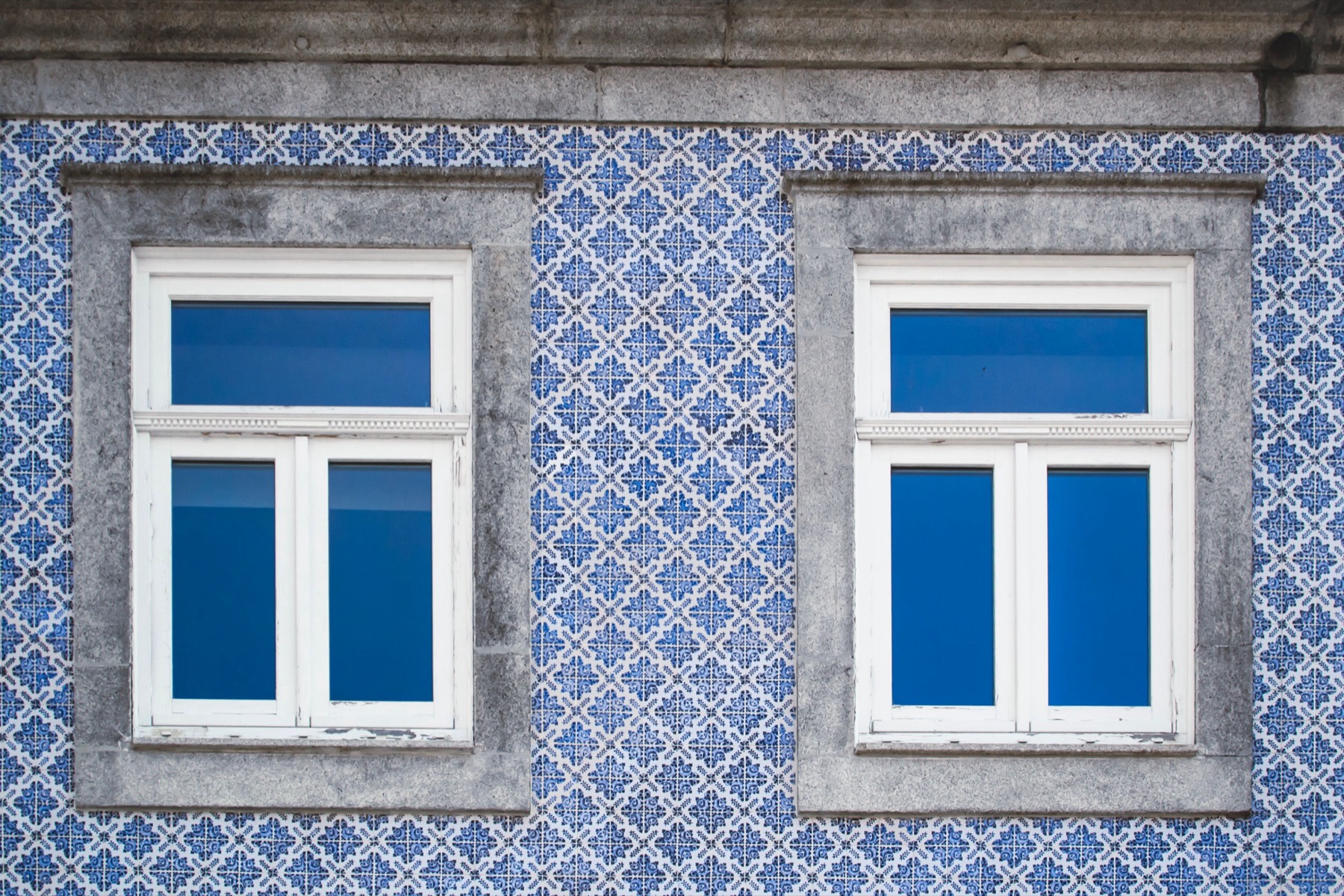 Classic Lisbon facade clad in blue-and-white Portuguese azulejo tiles around two white-framed windows