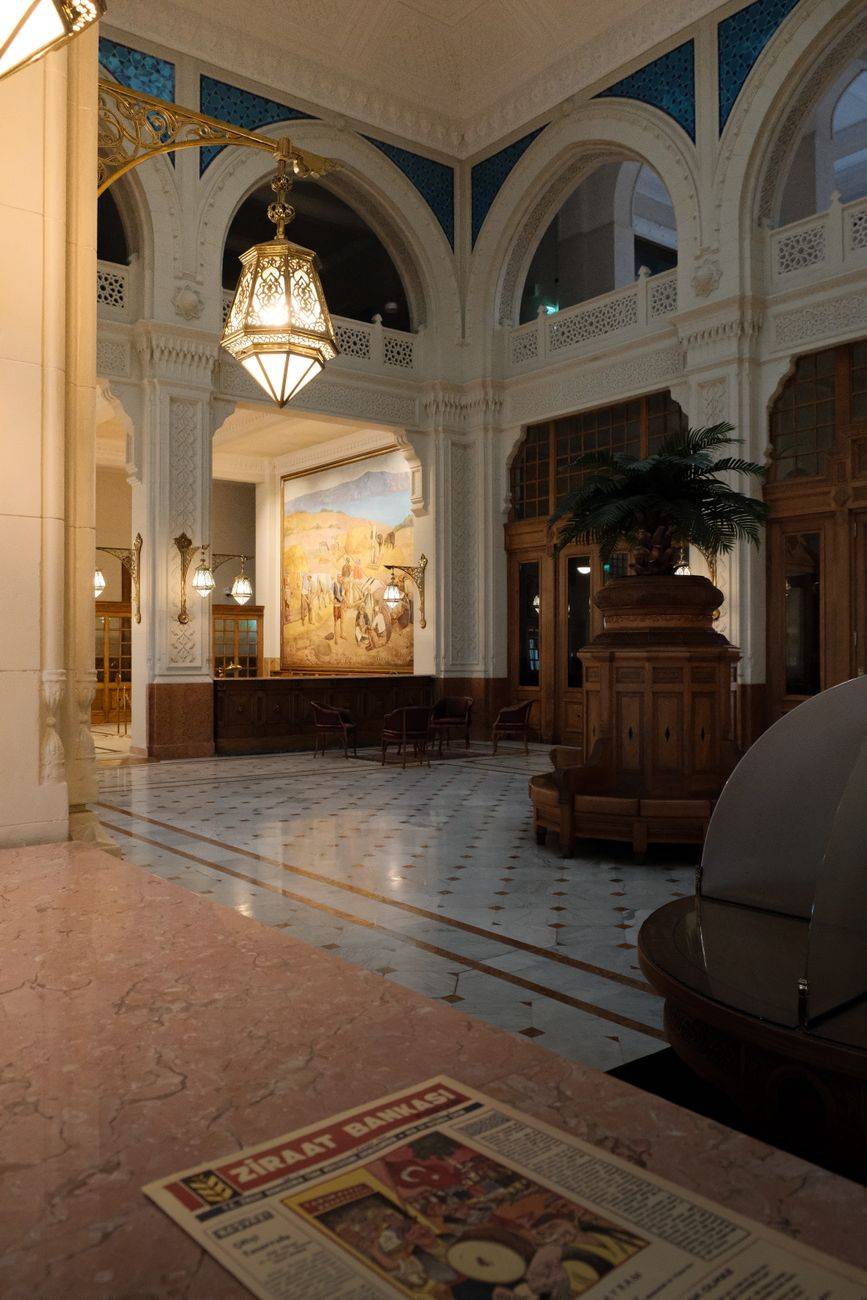 Elegant historic lobby with ornate architecture and warm lighting in an empty space.
