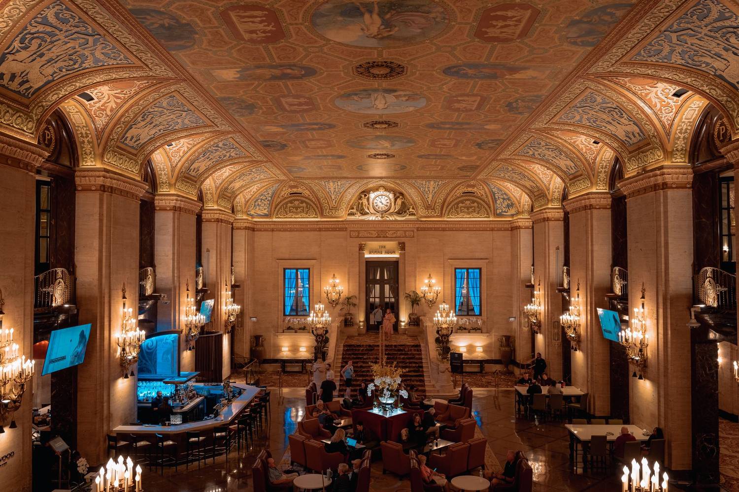 Luxurious hotel lobby with ornate ceiling and elegant chandeliers.