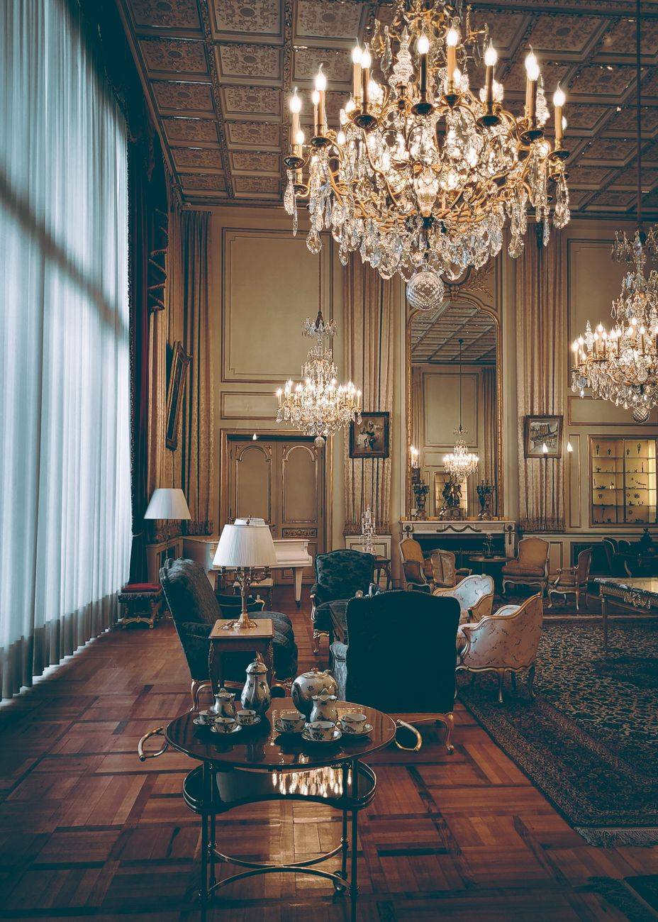Elegant hotel lobby with vintage decor and grand chandeliers.