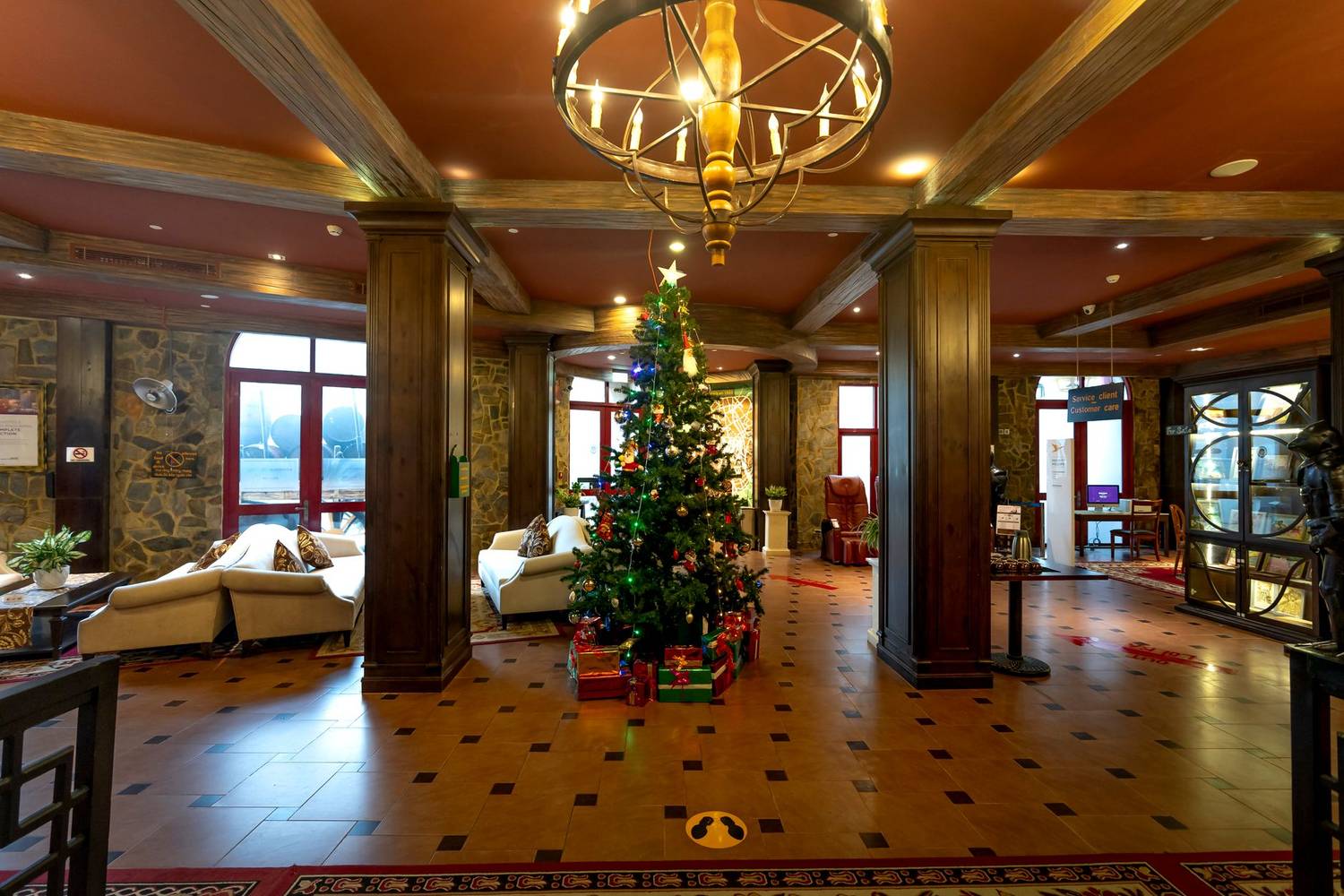 Elegant hotel lobby featuring a beautifully decorated Christmas tree, exuding a festive atmosphere.