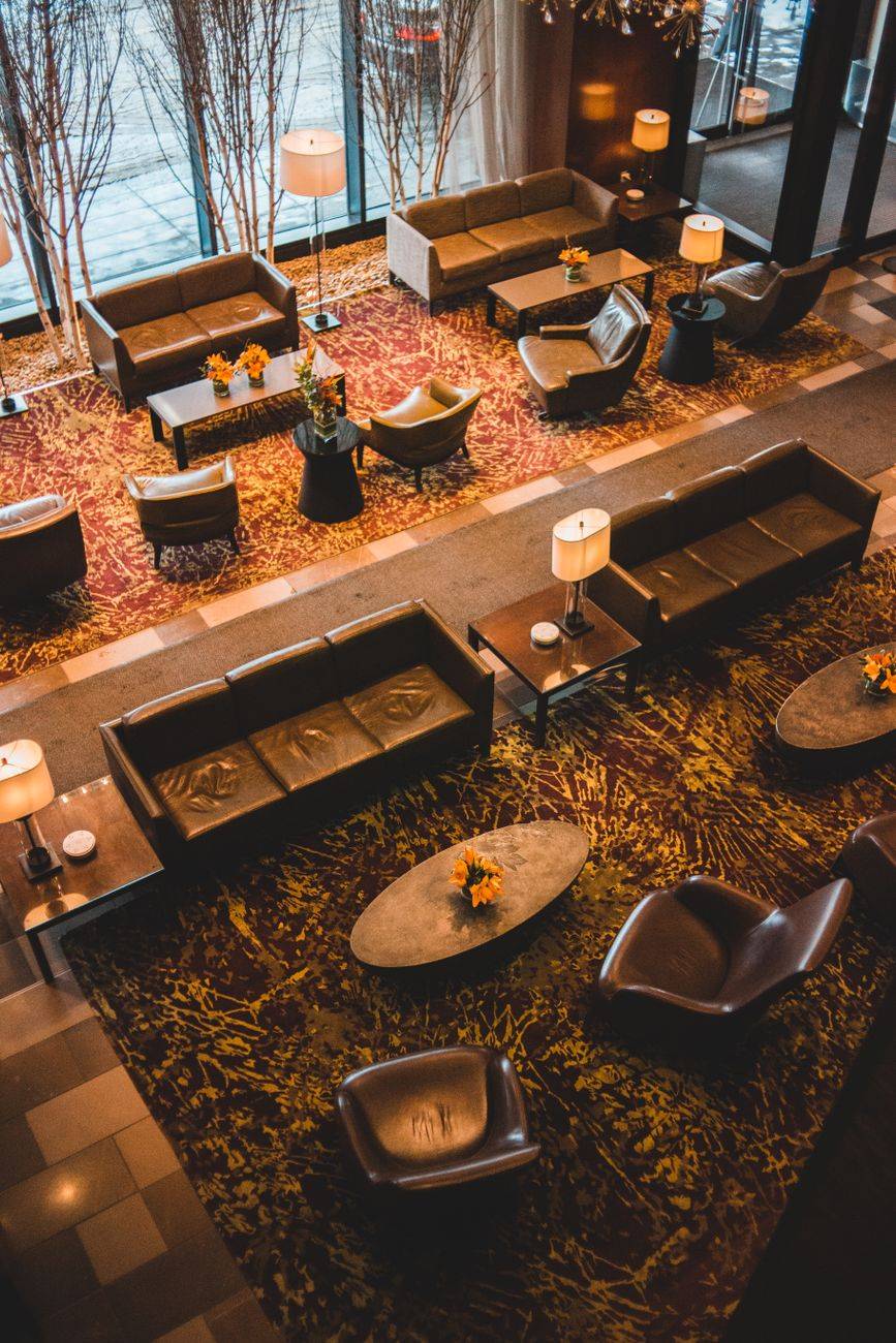 Modern hotel lobby with luxurious seating, contemporary design, and warm lighting from a high angle view.