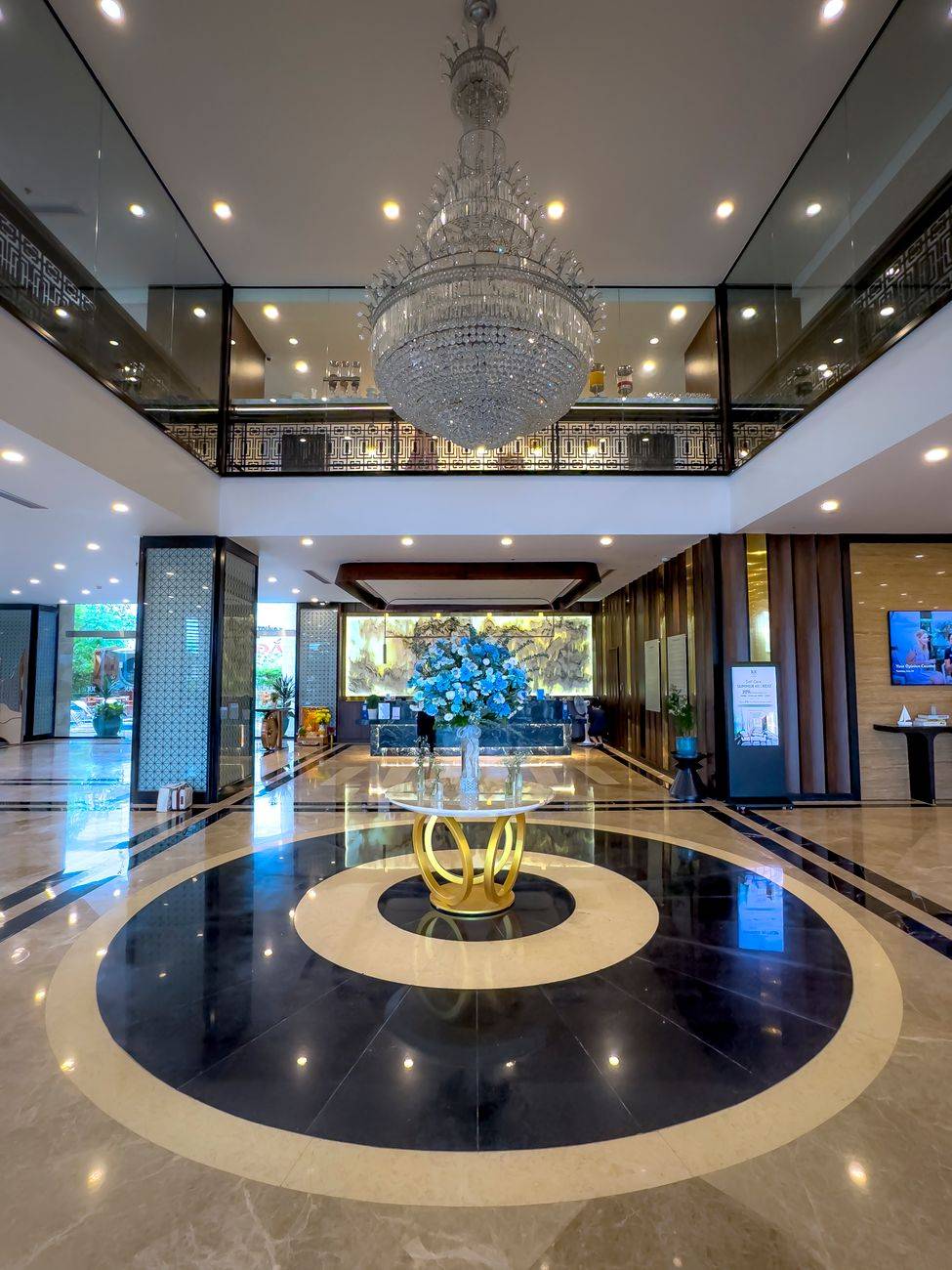 Luxurious hotel lobby featuring a large crystal chandelier and modern decor.