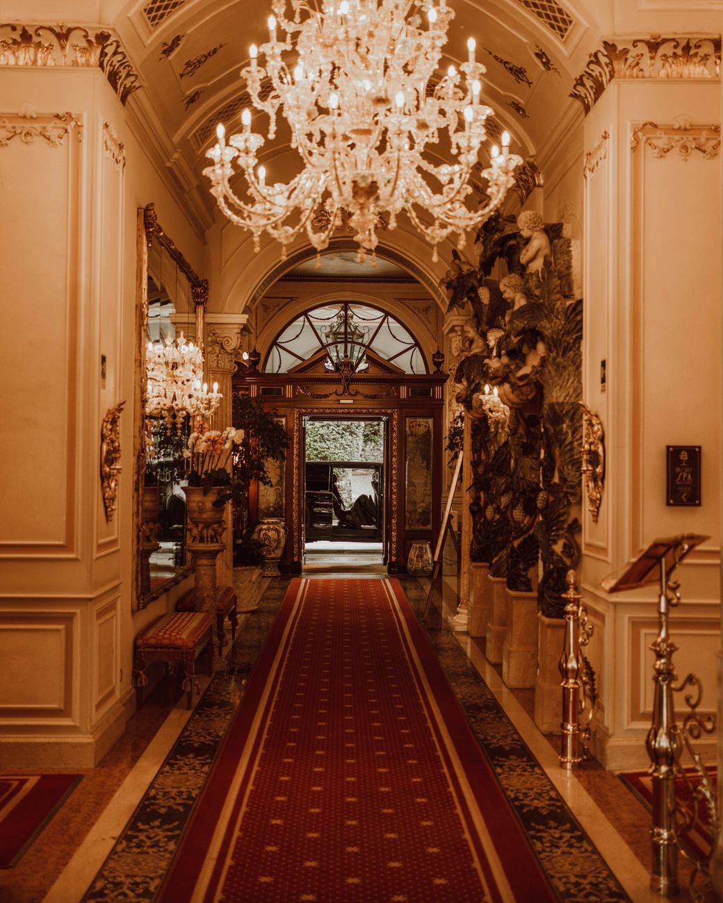 Luxurious hotel lobby in Stresa, Italy featuring a grand chandelier and classic interior design.