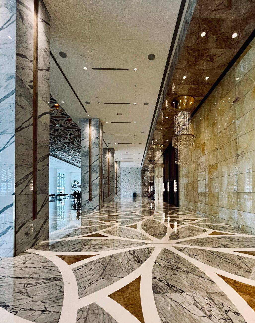 Impressive hotel lobby featuring intricate marble flooring and elegant chandeliers.