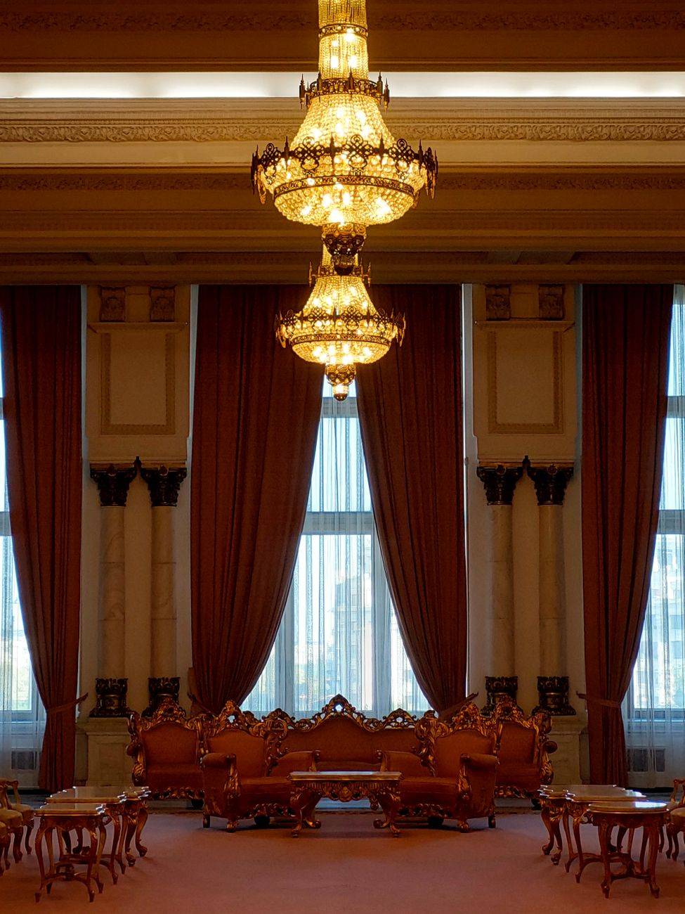 Opulent lobby interior featuring grand chandeliers, plush seating, and elegant decor.