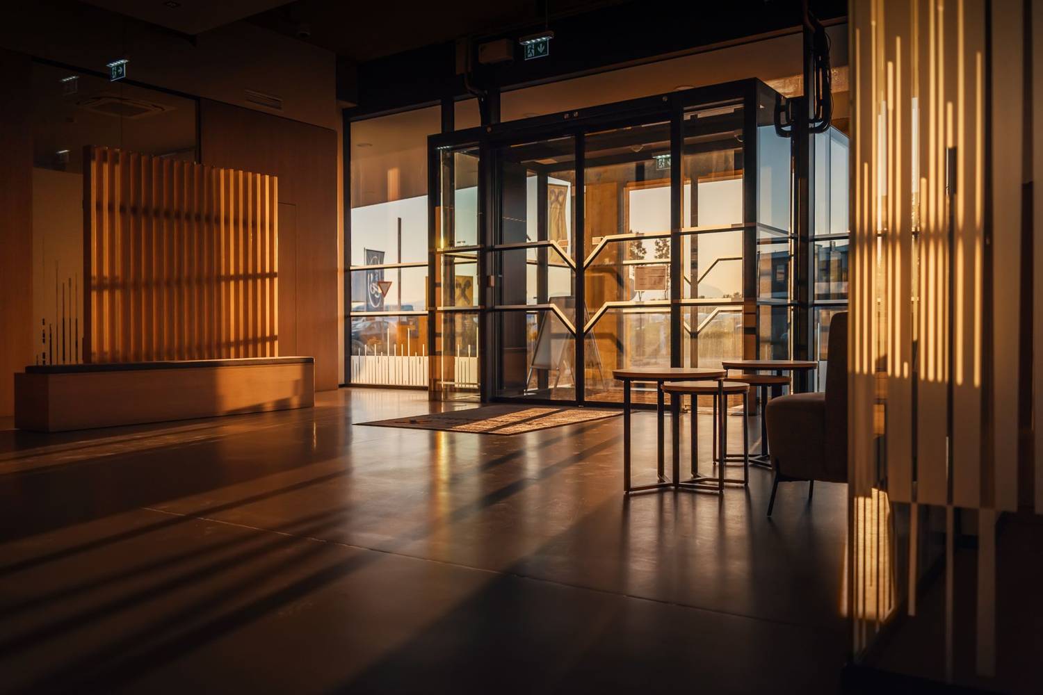 Sunlight streaming through a modern hotel lobby with glass doors in Steiermark, Austria.