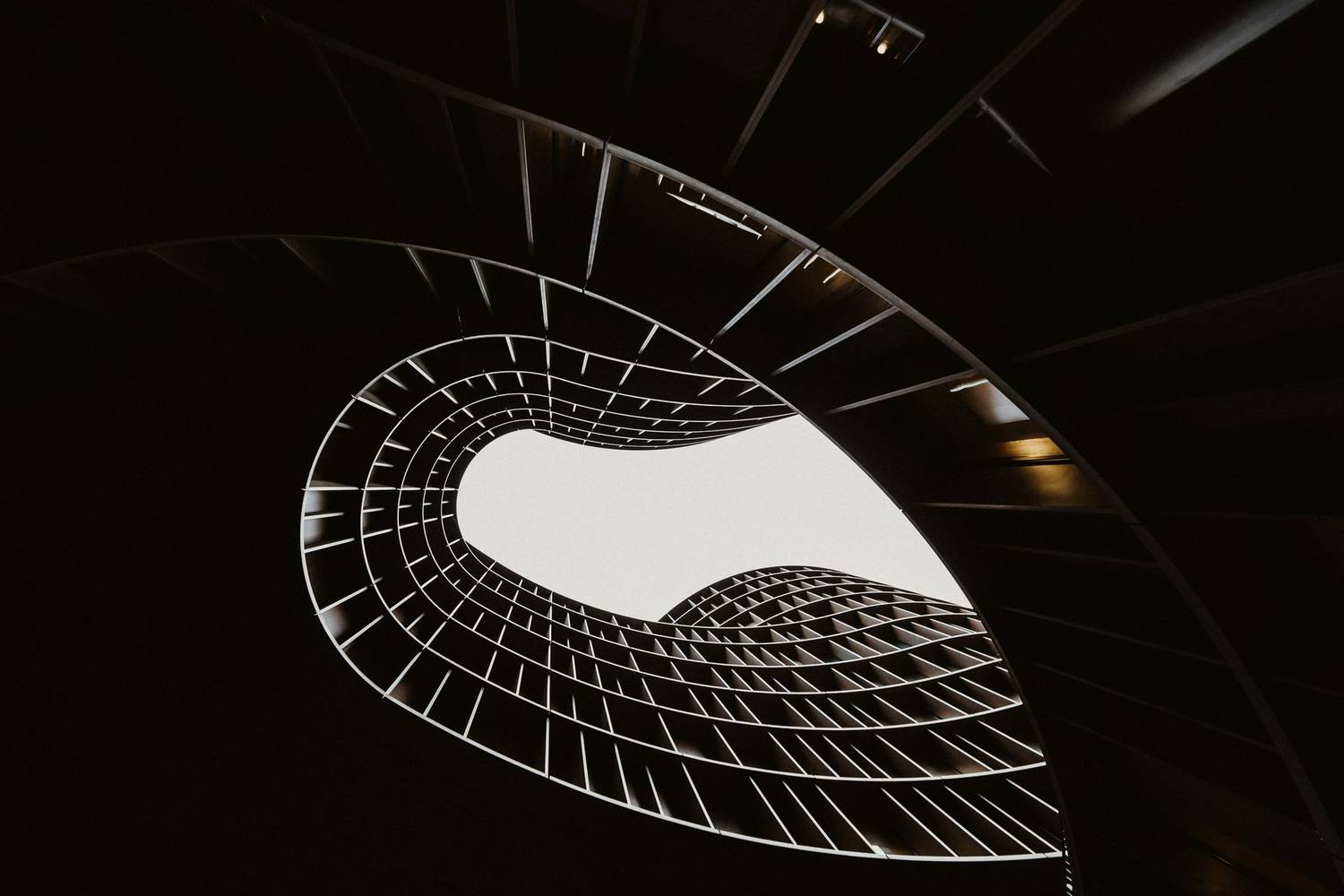 Abstract view of a modern spiral staircase in black and white highlighting architectural design.