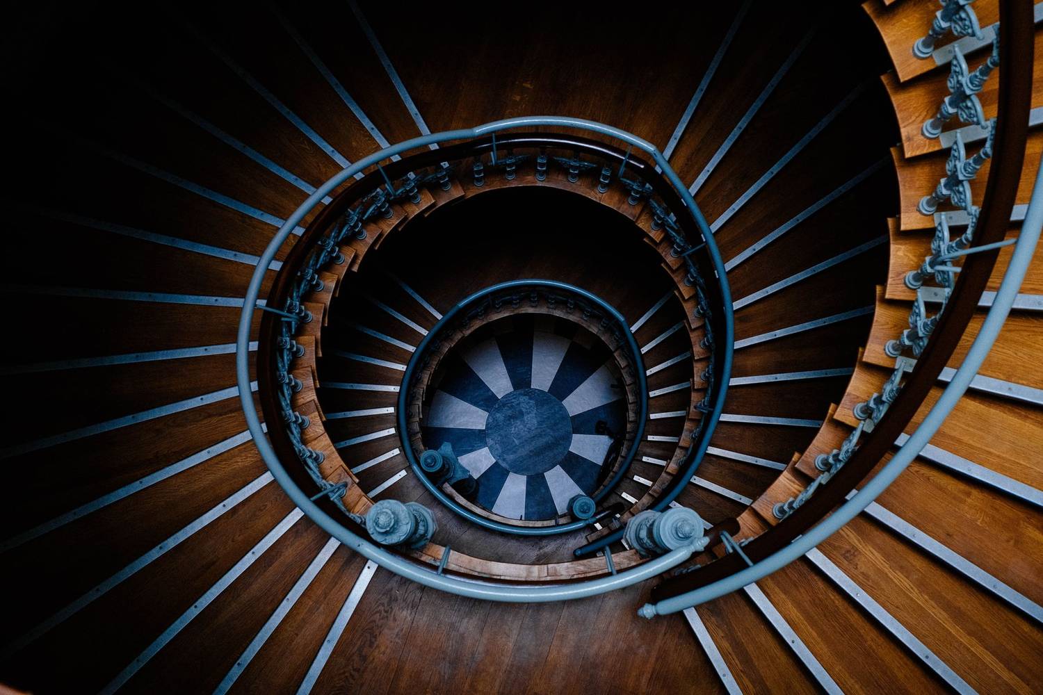 A top view of an elegant spiral staircase made of wood and metal, creating a captivating abstract pattern.