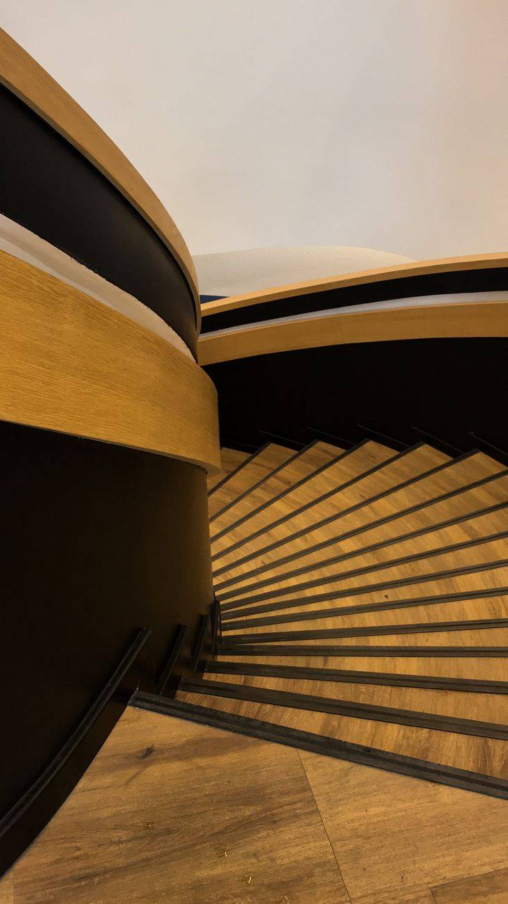 Sophisticated spiral staircase with wooden steps and elegant design in a modern setting.
