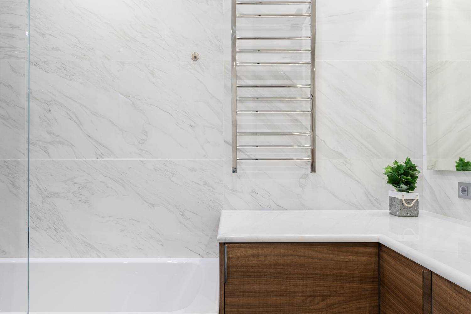 Interior of light modern bathroom with potted green plant on cabinet under mirror on white tile