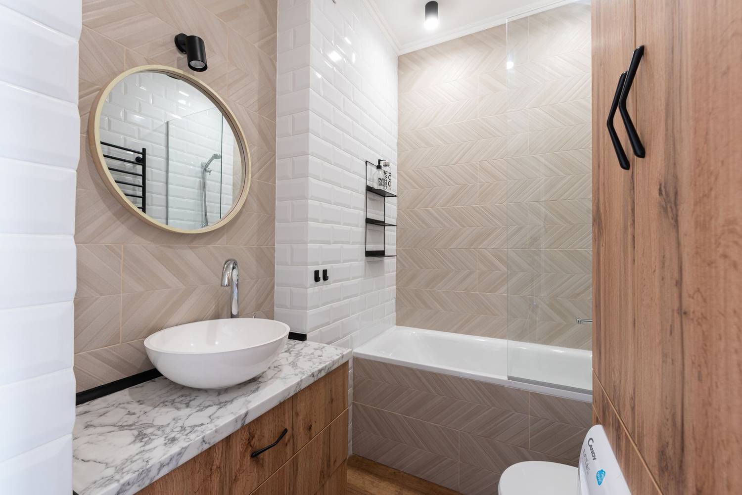 Interior of modern bright restroom with sink and faucet on cabinet under mirror on tile wall next to bathtub
