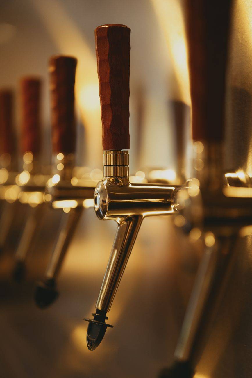 Artistic shot of beer tap handles with warm lighting, perfect for modern bar themes.