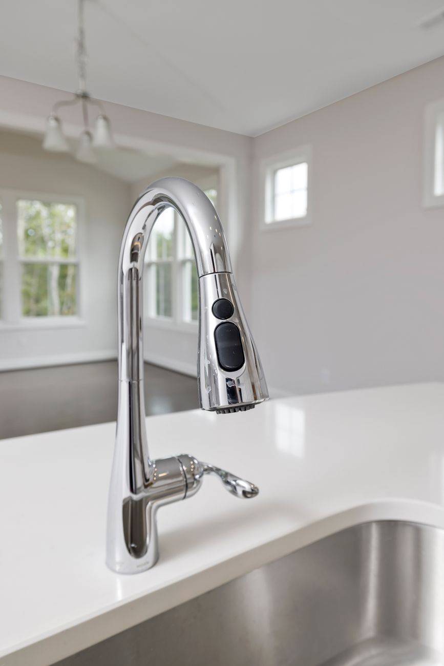 Elegant stainless steel kitchen faucet with a sleek design in a modern interior setting.