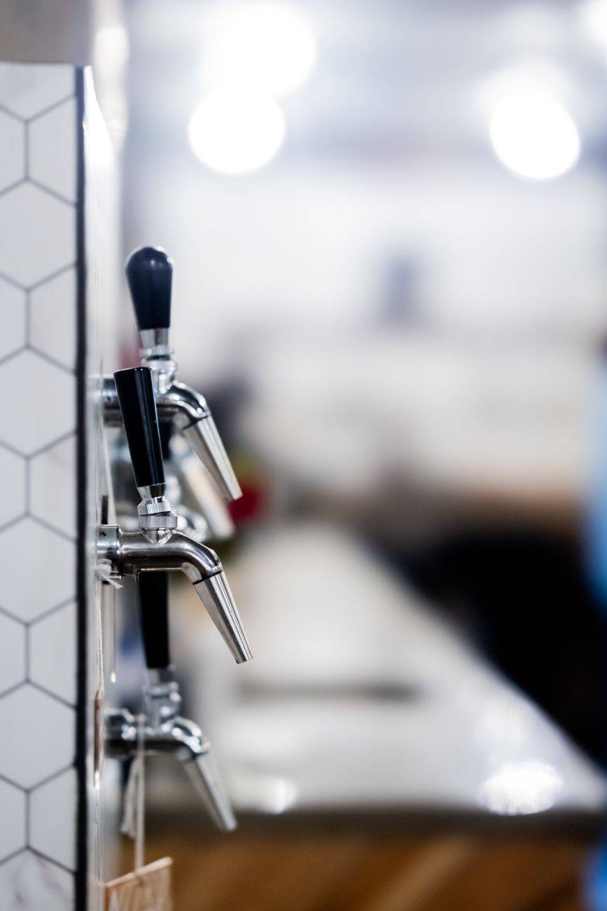 Close-up of sleek beer tap handles in a modern bar with blurred background. Perfect for hospitality and lifestyle imagery.