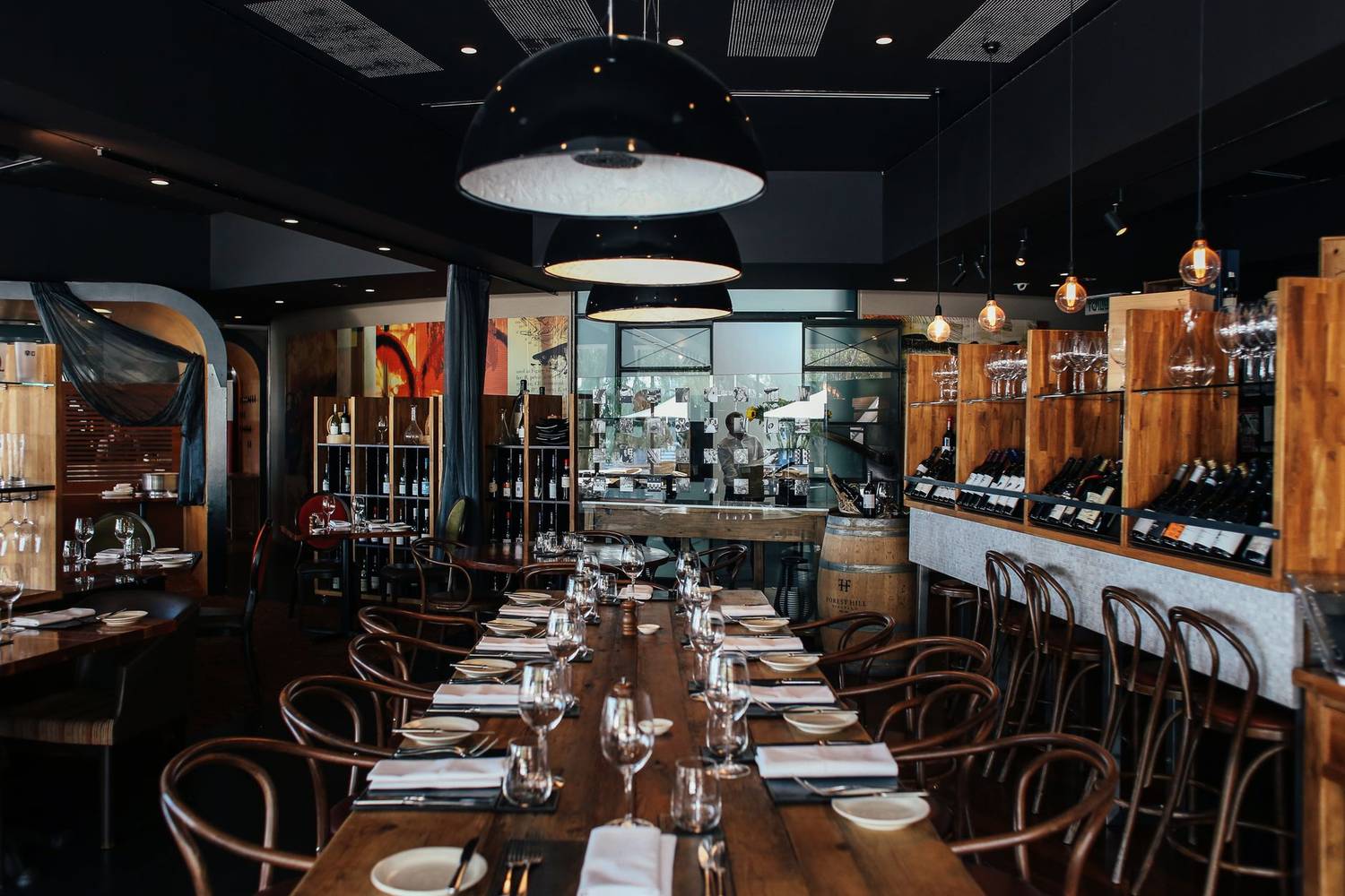 Stylish restaurant interior with wooden decor and table settings for a cozy dining experience.