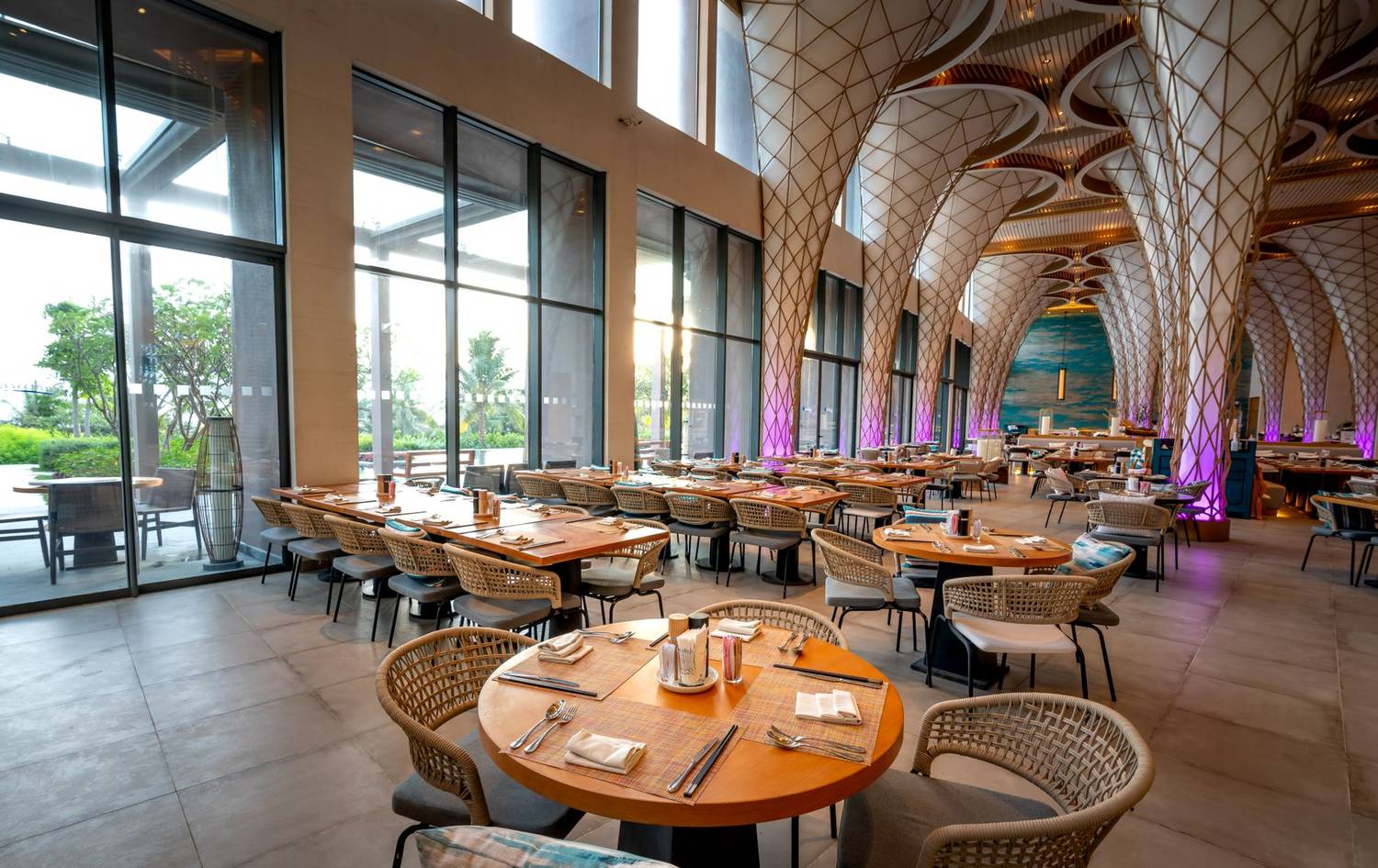 Luxurious restaurant dining area with artistic architecture and empty tables.