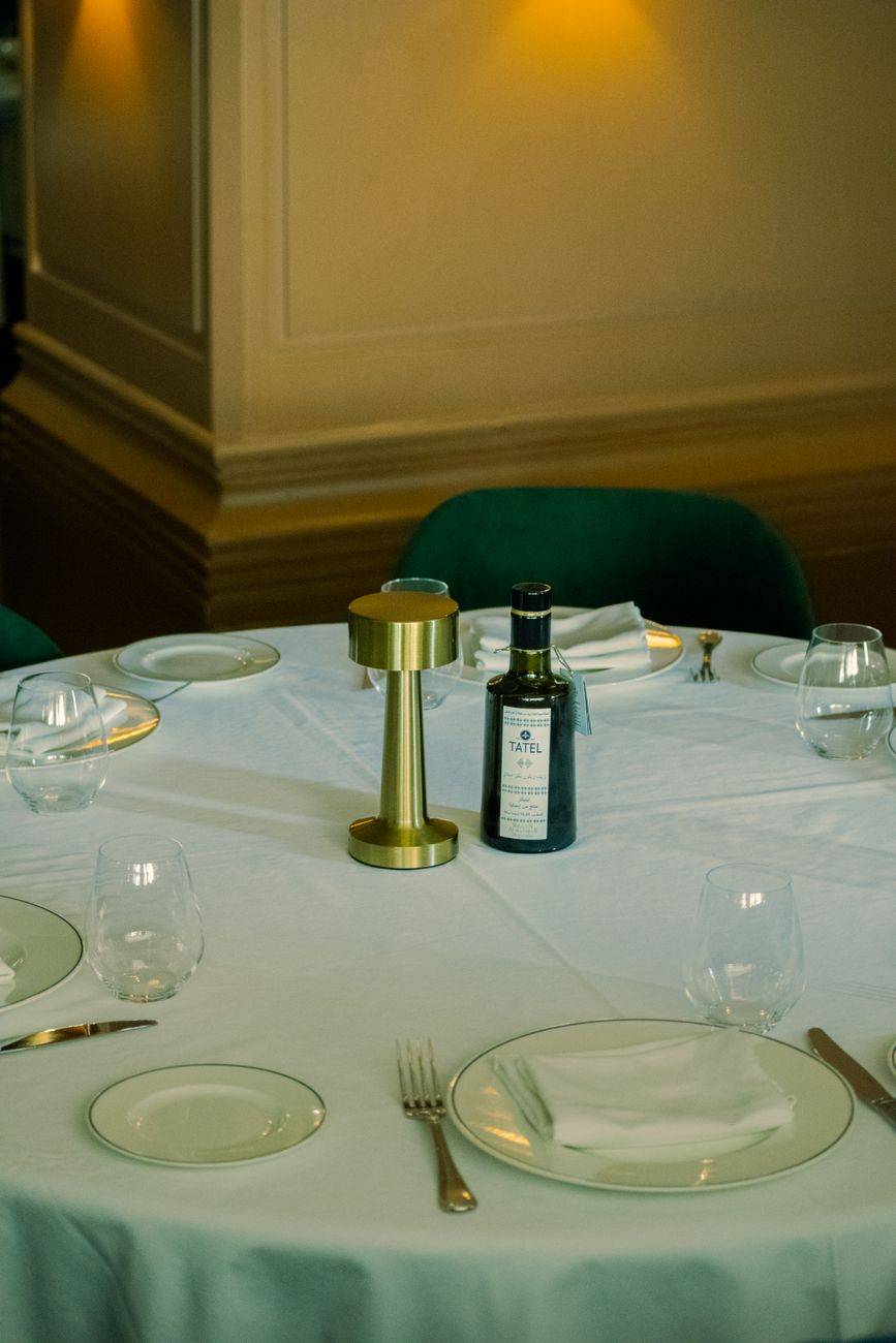 A sophisticated dining table setup with a bottle and classic tableware in a restaurant.