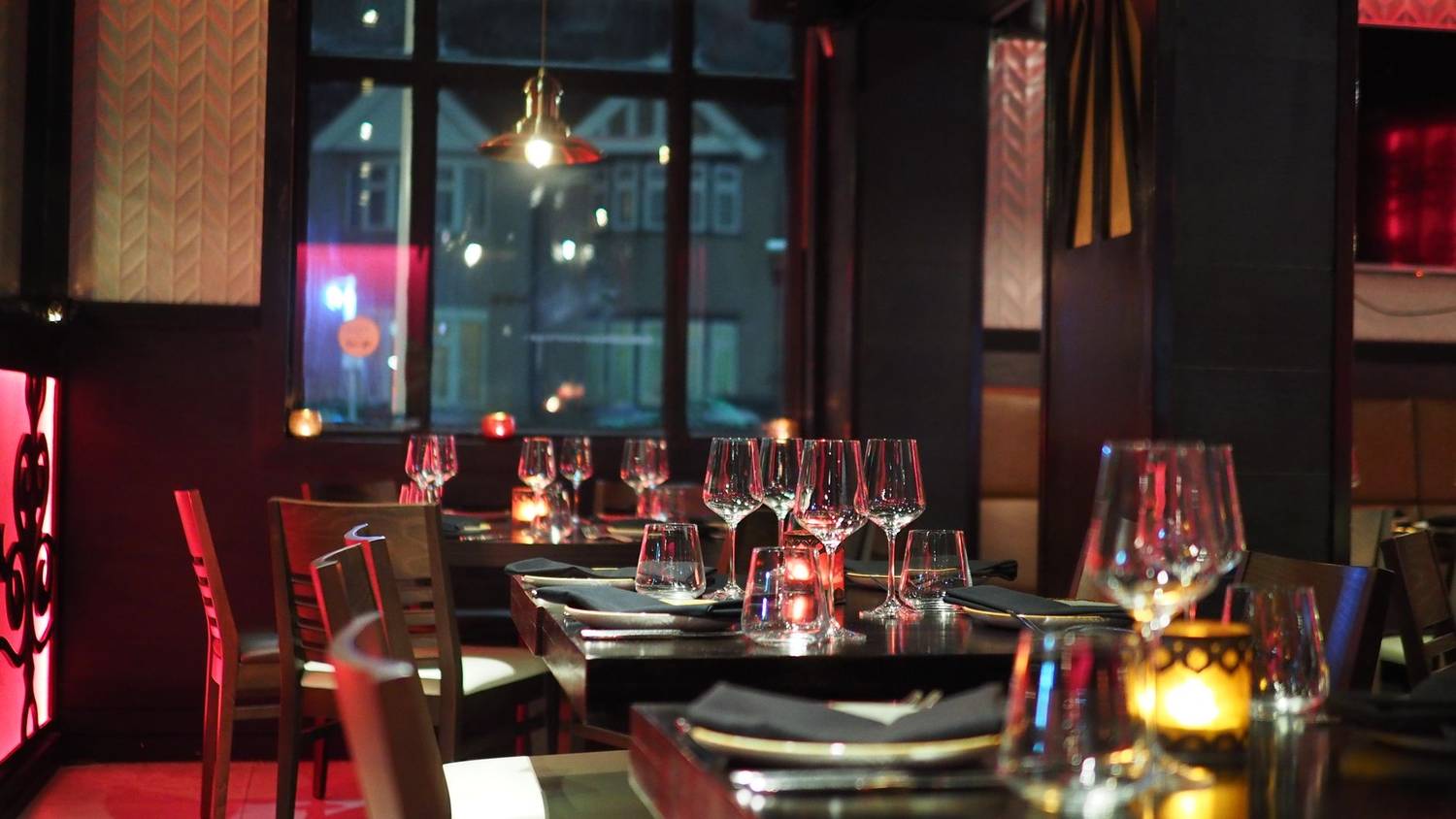 A sophisticated restaurant interior with elegant table setting and ambient candlelight, creating a cozy atmosphere.
