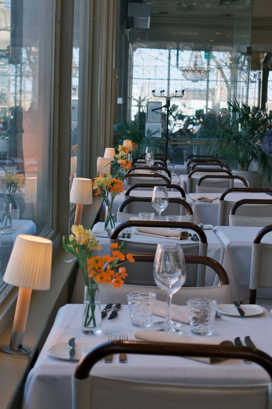 Inviting restaurant interior featuring elegant table settings and vibrant floral decorations.