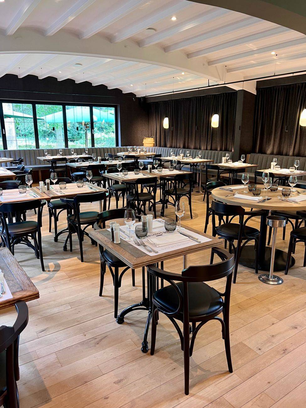 Chic restaurant interior with arranged tables and stylish lighting, offering a cozy dining atmosphere.