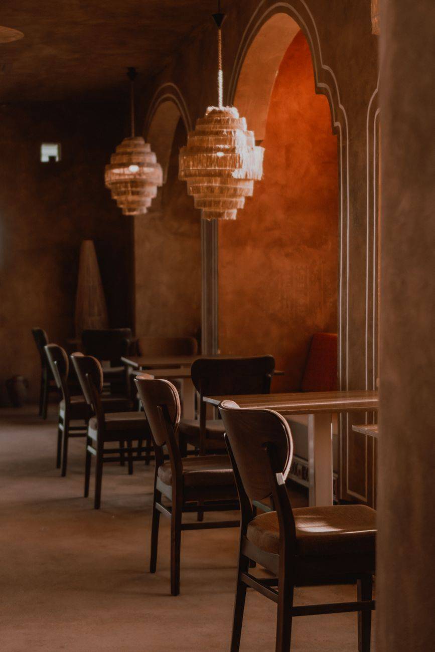 Warm, elegant restaurant interior featuring arched walls and chandelier lighting creating a cozy atmosphere.