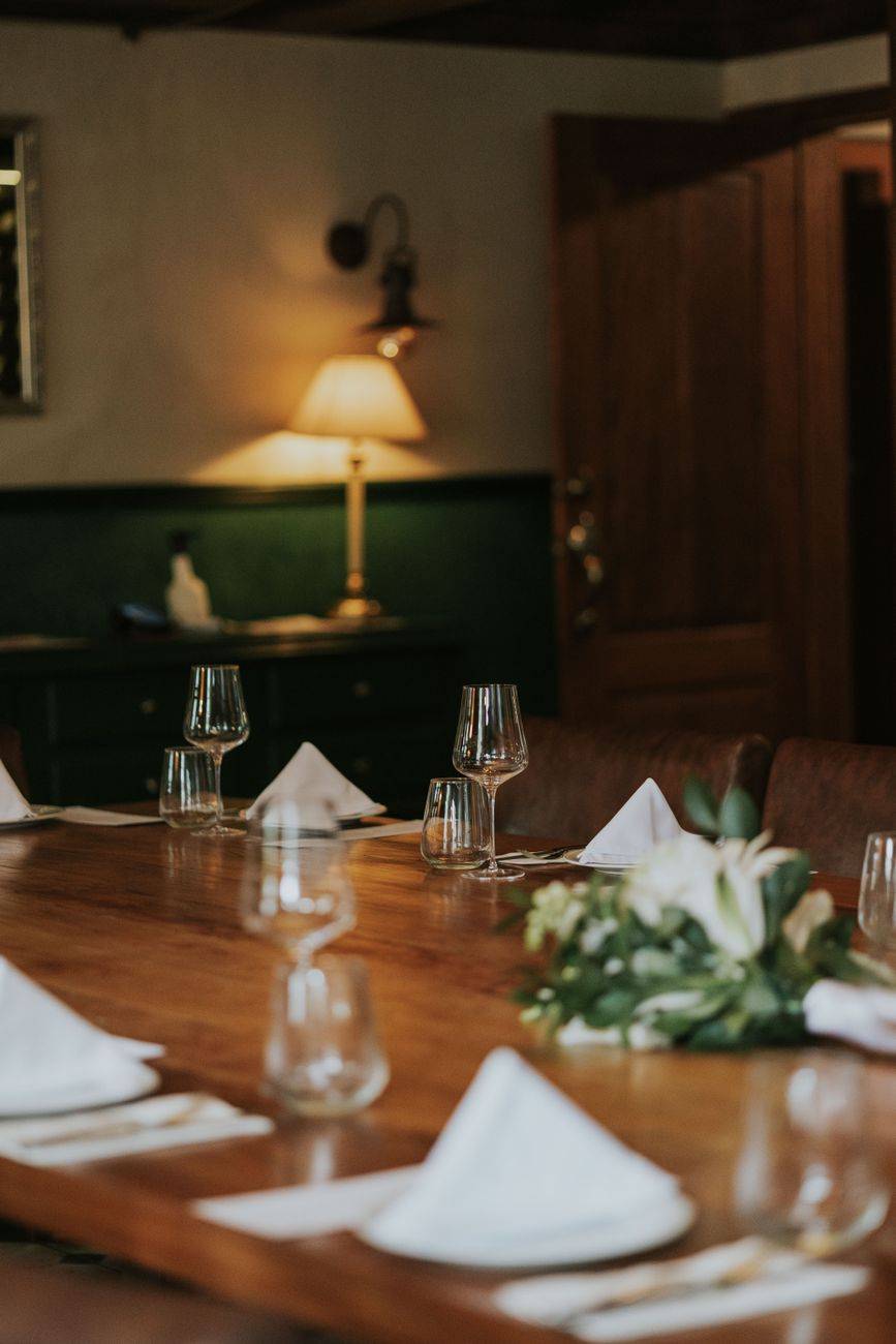 Warm and inviting dining room with elegantly set table, featuring glassware and folded napkins.