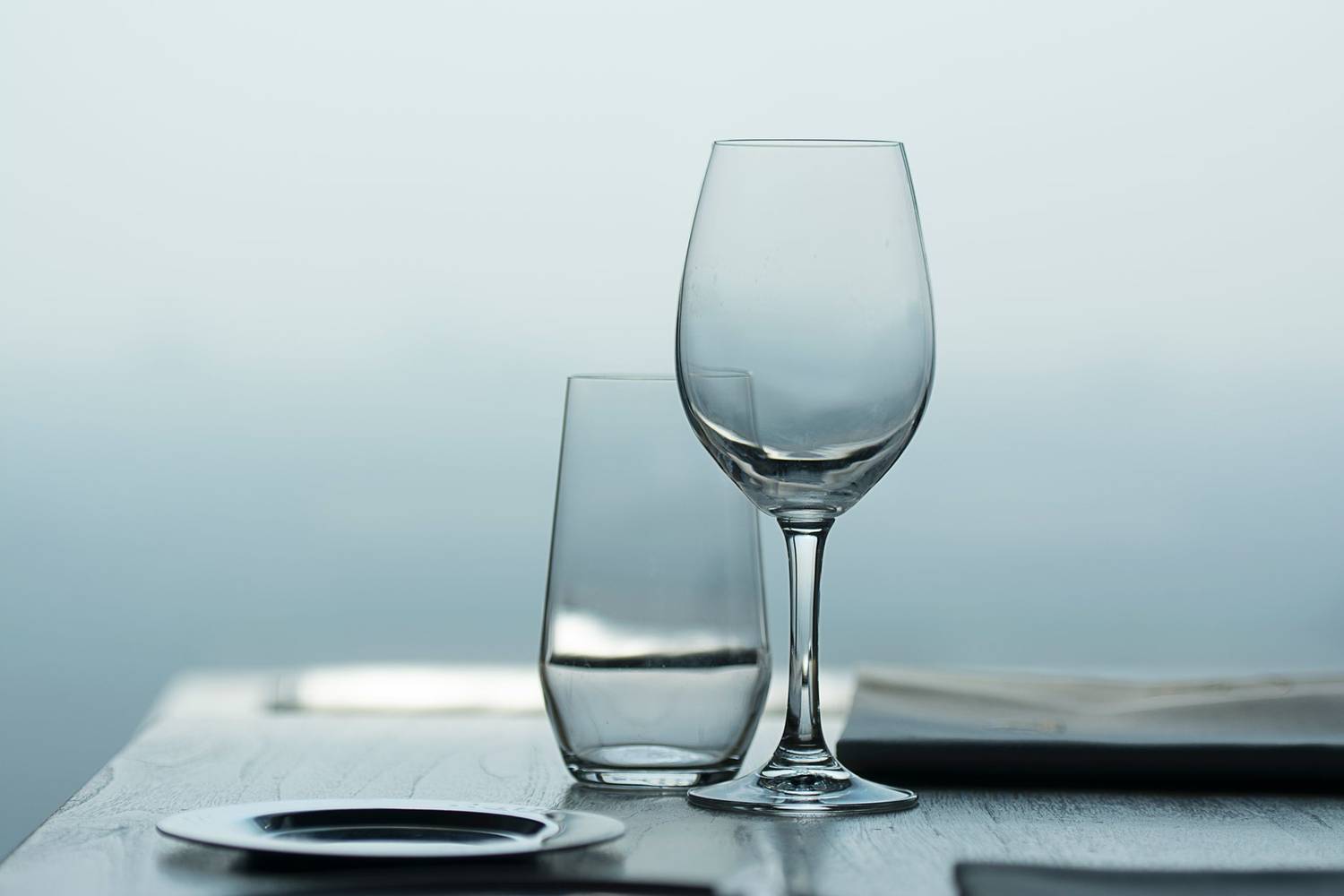 Close-up of a wine and water glass on a table with soft focus background.
