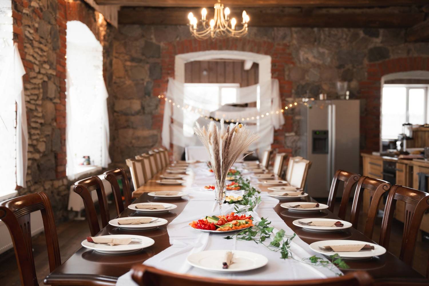 A beautifully set long dining table in a rustic room, ideal for events or weddings.