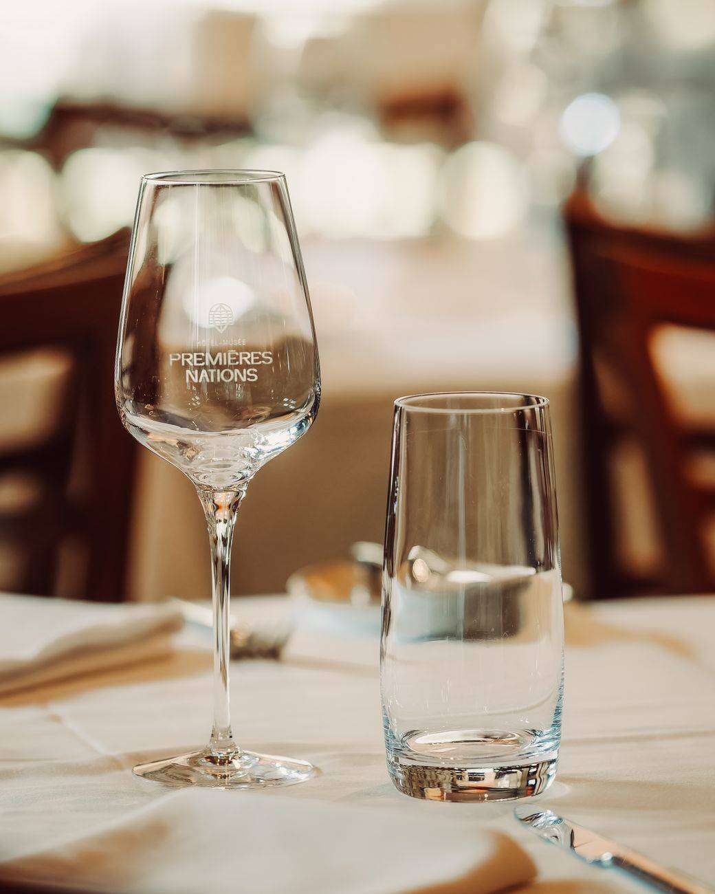 Stylish table setting with a wine glass displaying a logo, perfect for dining ambiance.