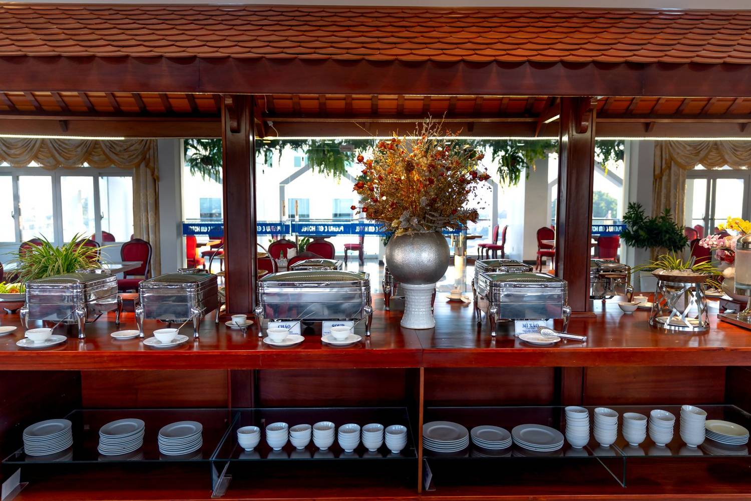 Elegant buffet counter with stainless setup in a bright, stylish restaurant interior.