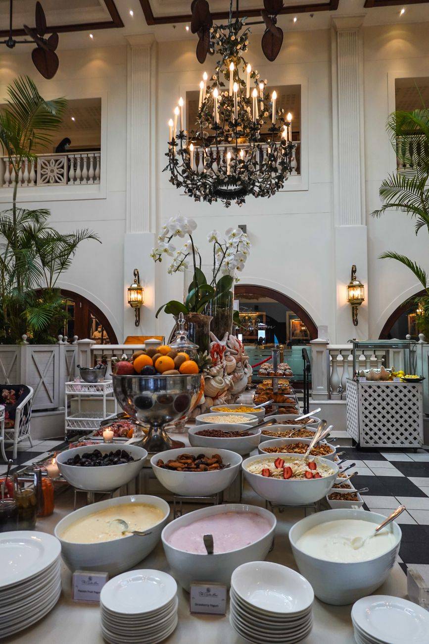 Elegant hotel dining hall featuring a diverse buffet with luxurious decor and chandeliers.