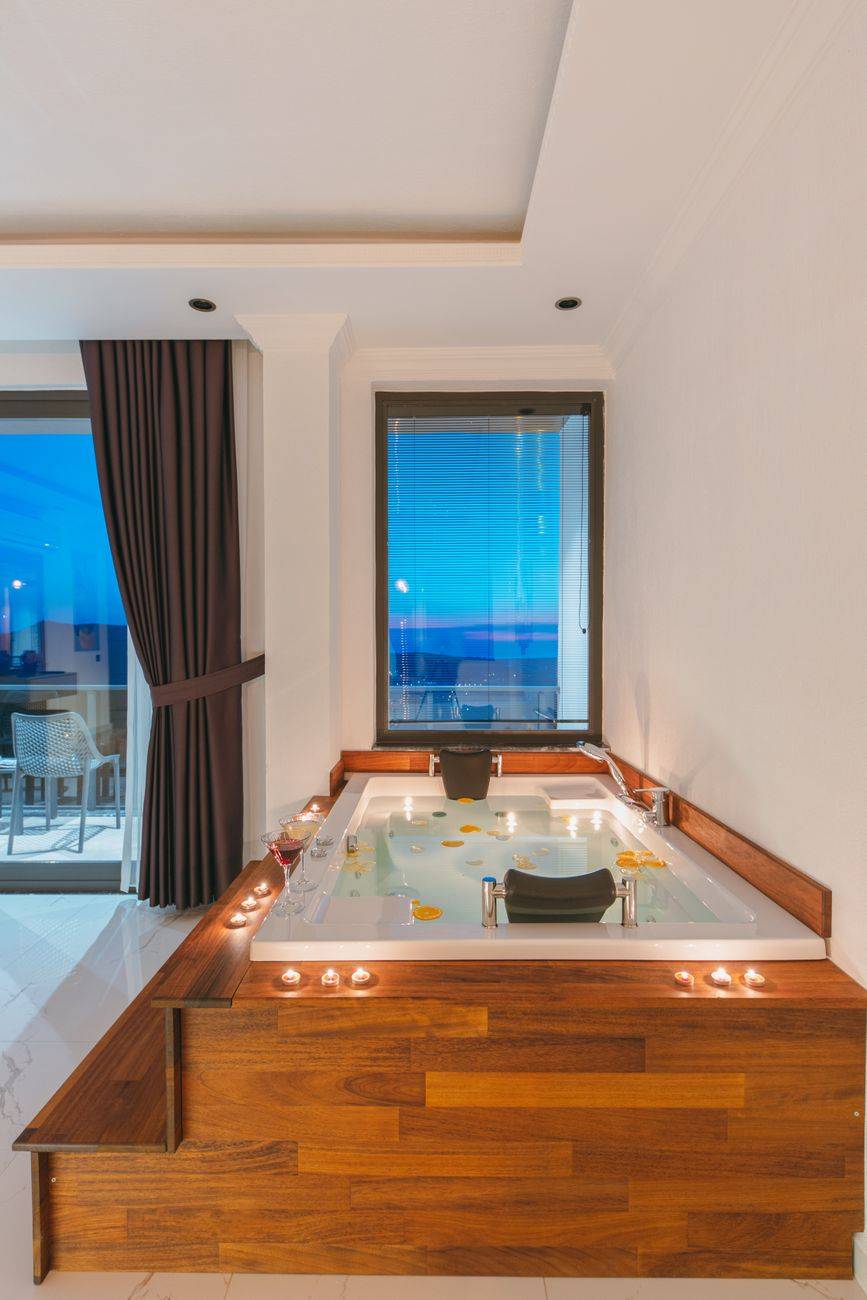 Luxurious indoor spa scene with ambient candles and ocean view, perfect for relaxation.