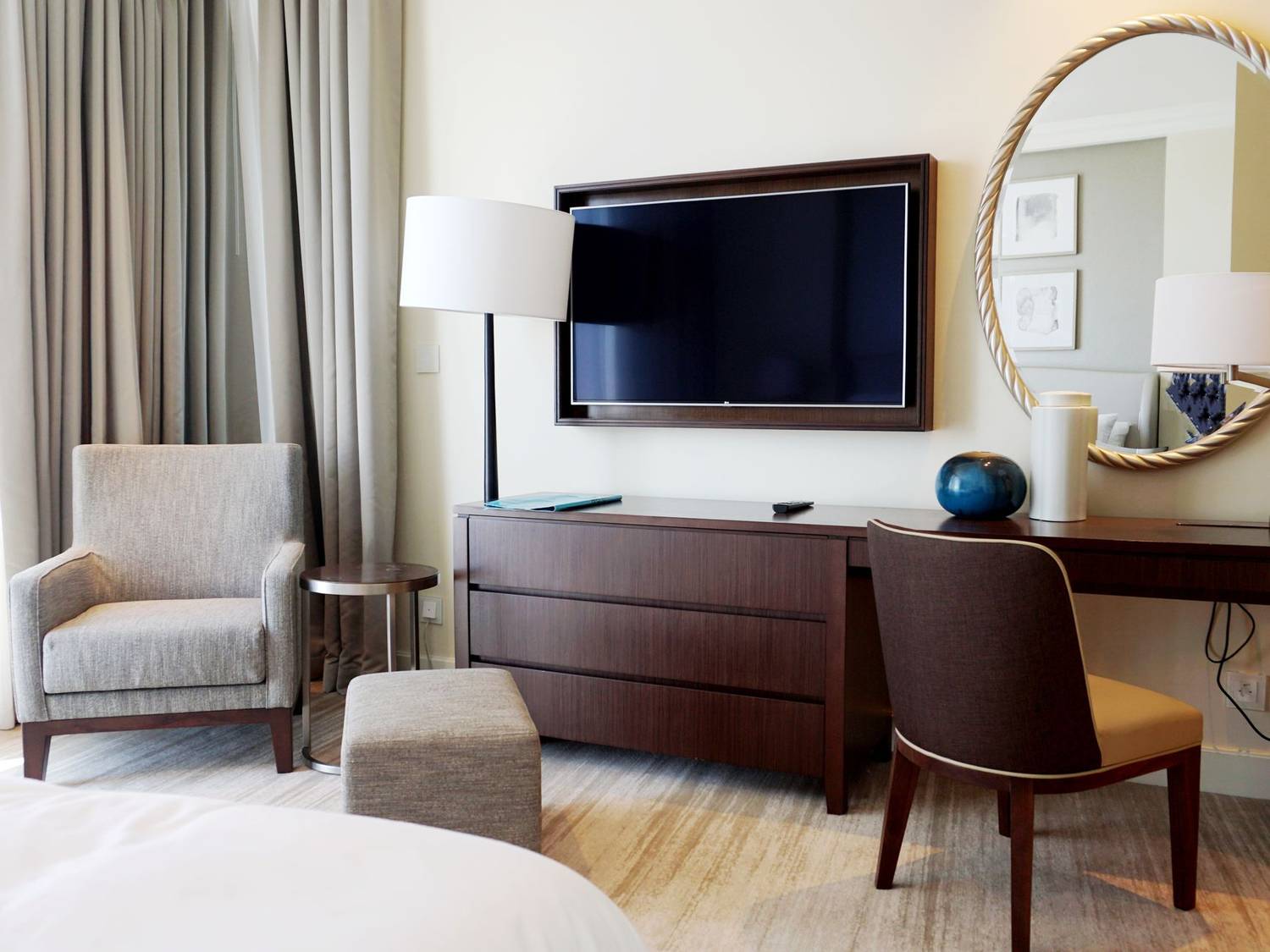 Chic hotel room with elegant modern furniture and decor, featuring a large wall-mounted TV.