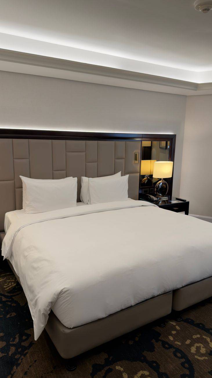 Spacious hotel room featuring a large bed and stylish decor, ideal for travelers seeking comfort.