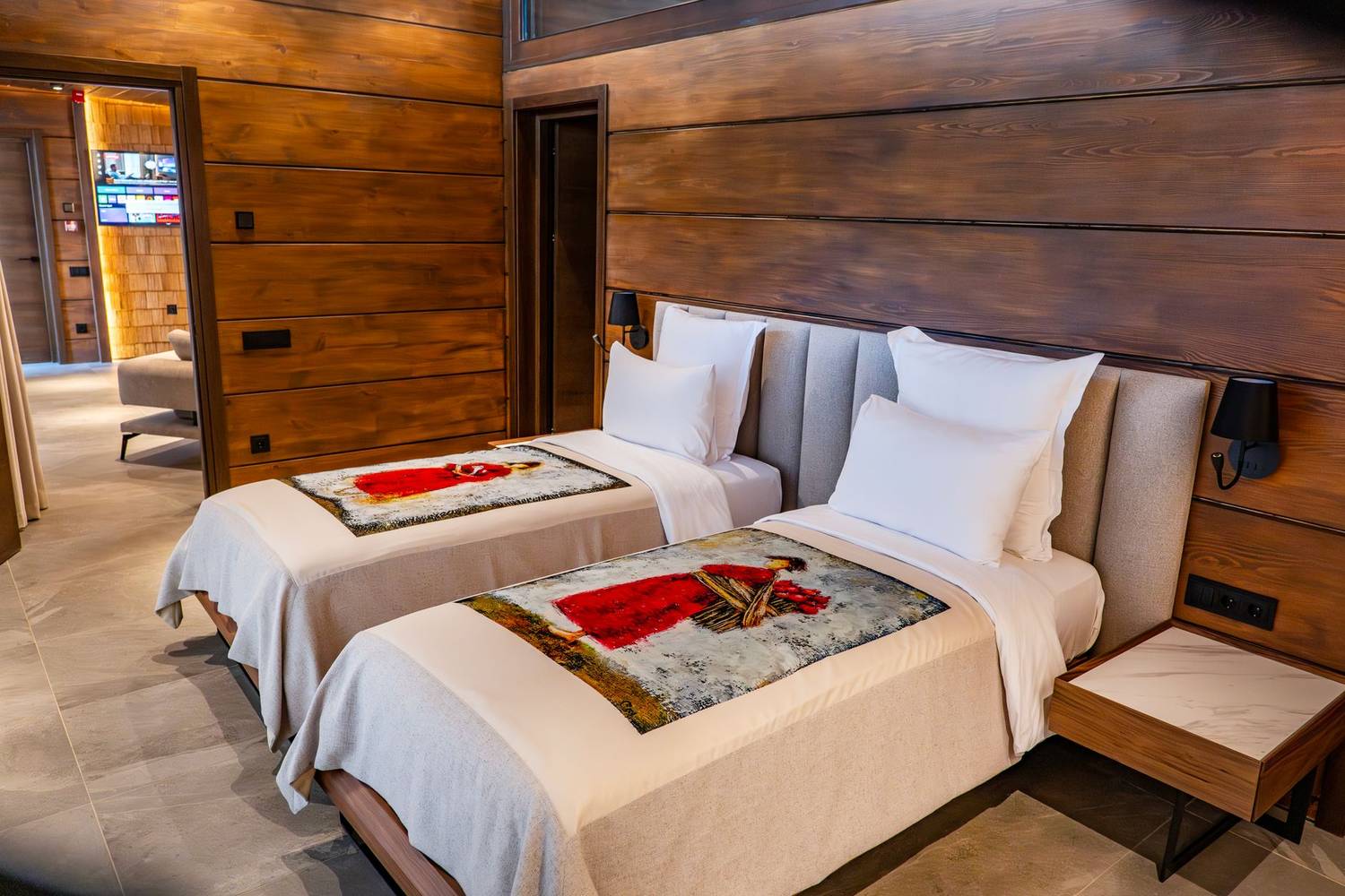 Cozy twin bedroom with wooden paneling and modern decor in a luxury Tbilisi hotel.
