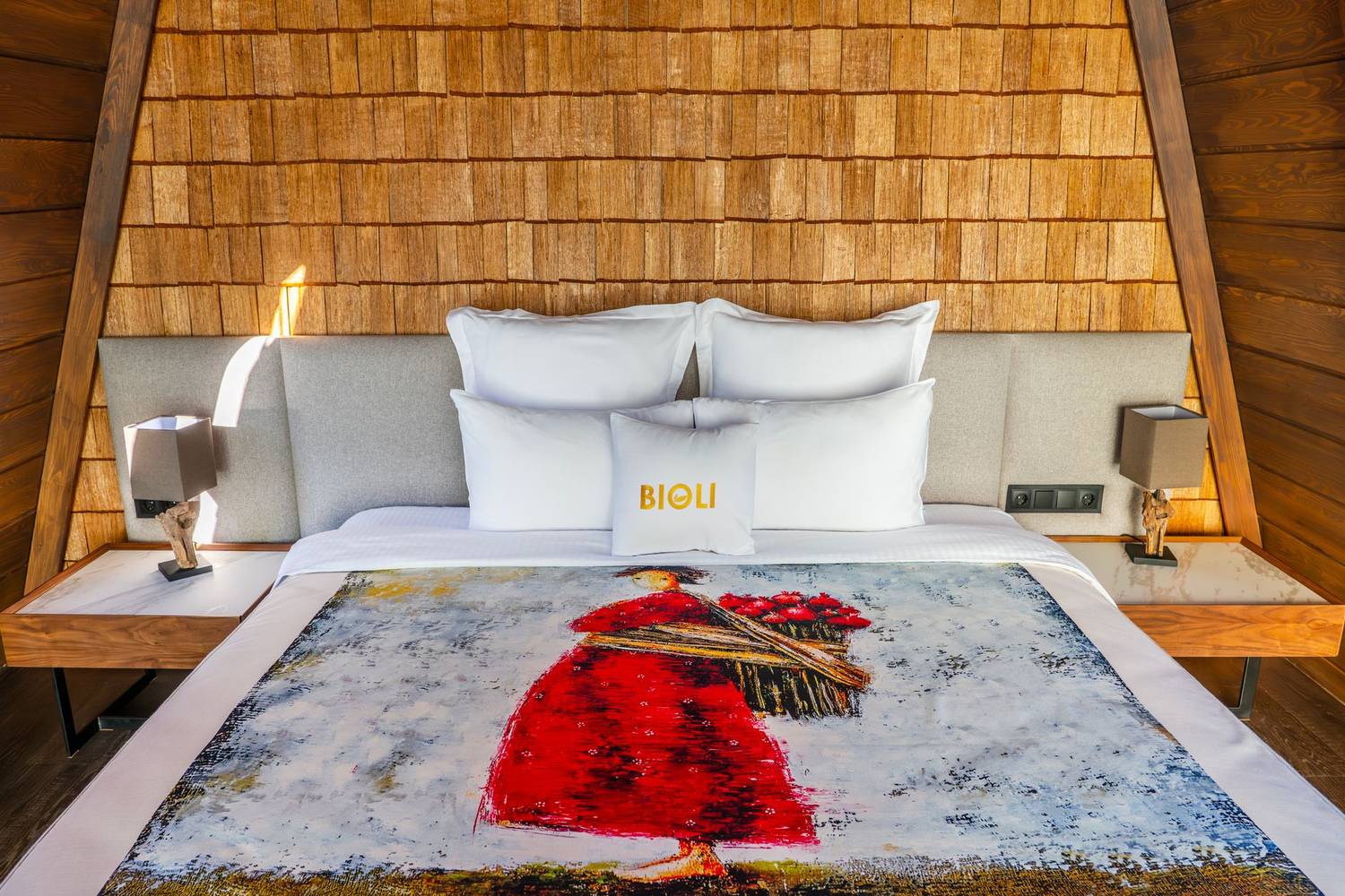 A luxurious bedroom interior with a wooden theme in a Tbilisi hotel, featuring a stylish bedspread.