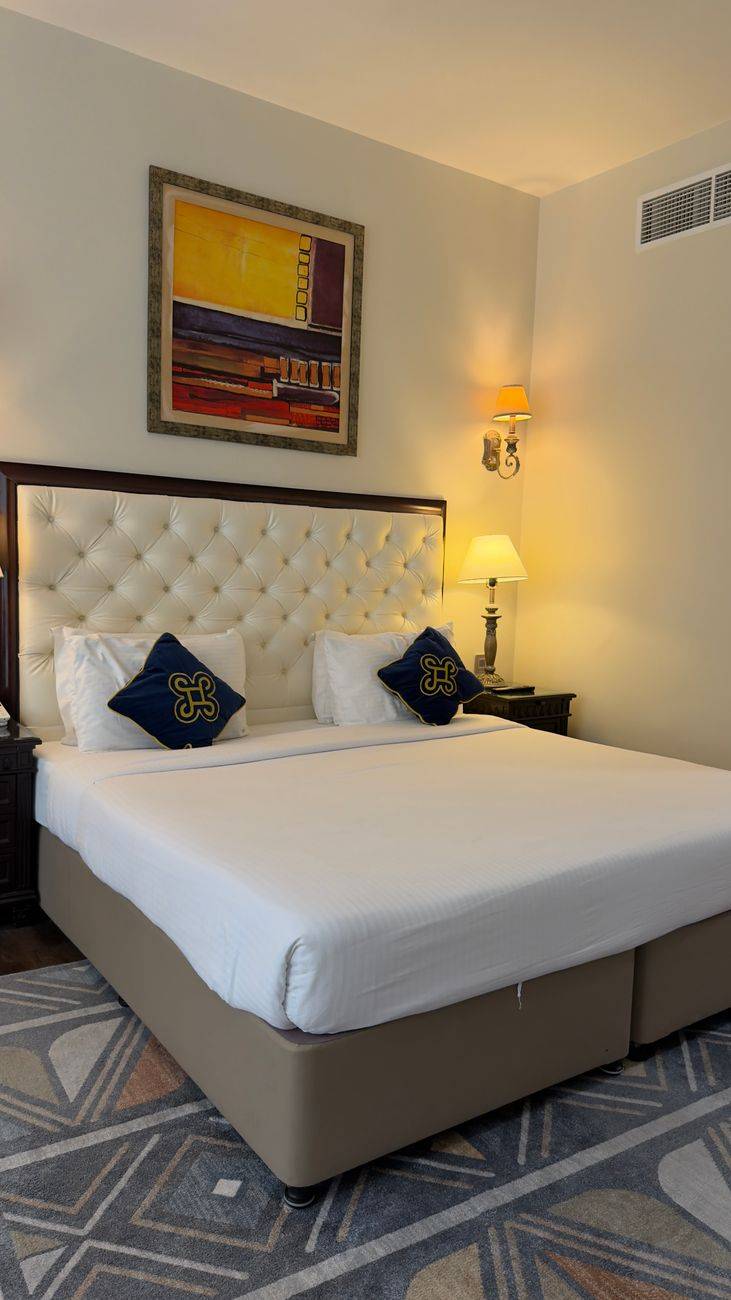 Luxurious hotel bedroom with stylish decor and comfortable bed, showcasing modern elegance.