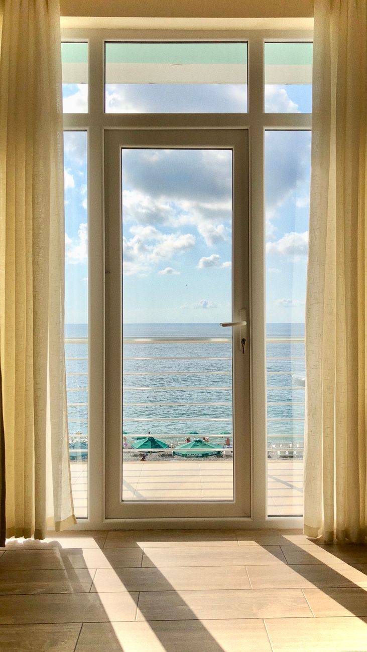 Relaxing ocean view from a hotel room window in Batumi, Georgia, with clear blue skies and sea.