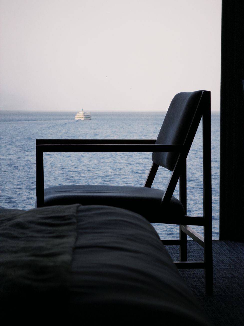 Simple, elegant interior with a sleek chair by the ocean, perfect for a tranquil escape.