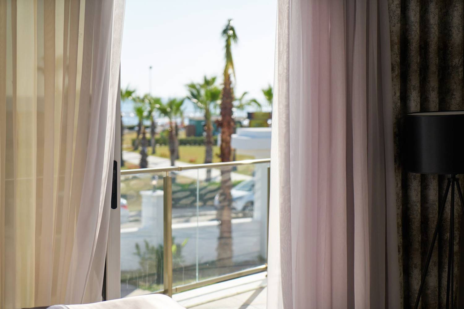 Luxurious hotel room featuring a stunning beach view through elegant sheer curtains. Perfect for relaxation and travel enthusiasts.