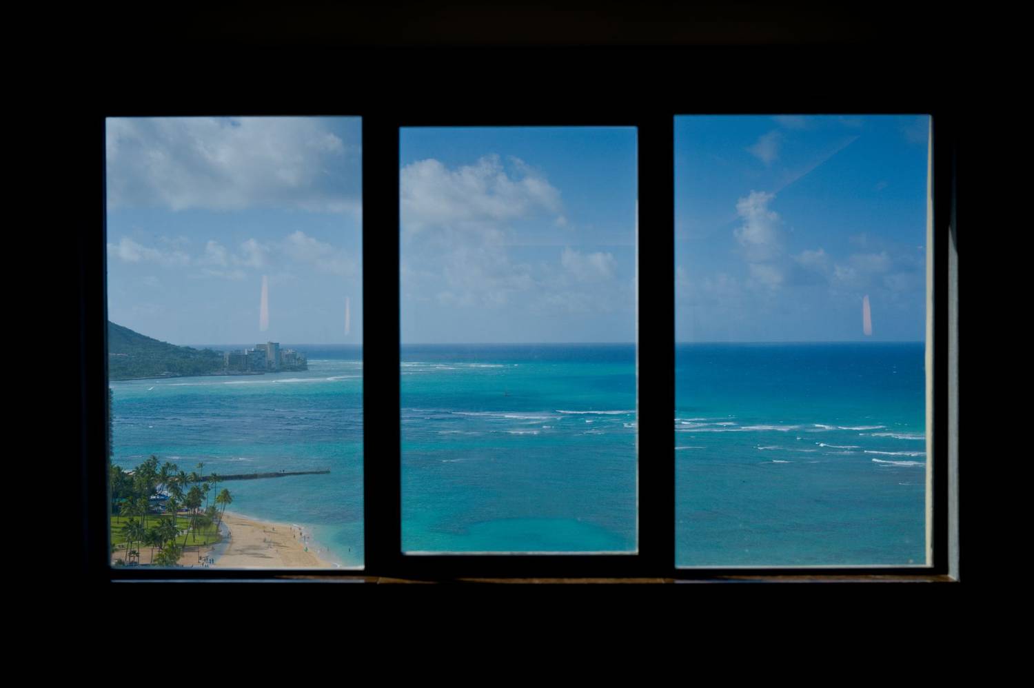 Stunning view of the Pacific Ocean and clear blue skies seen through window panes.