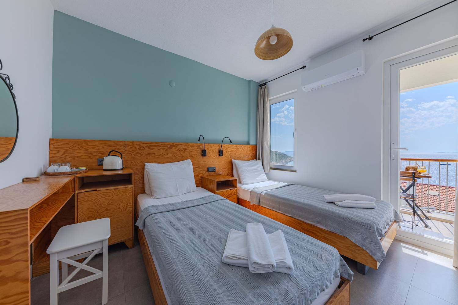 Bright hotel room with twin beds and ocean view balcony. Perfect for travelers.