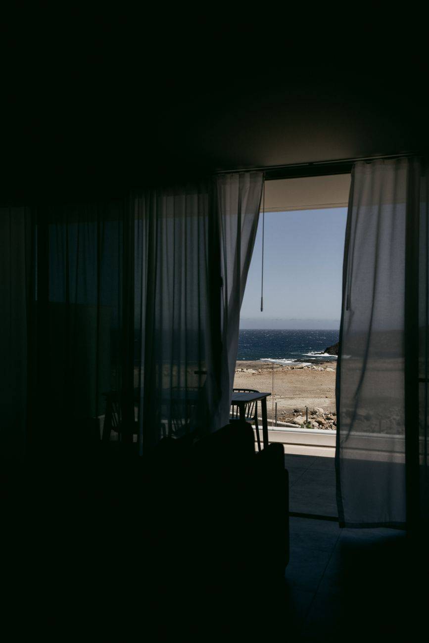 Gorgeous seaside view through sheer curtains, offering a serene and minimalist ambiance.