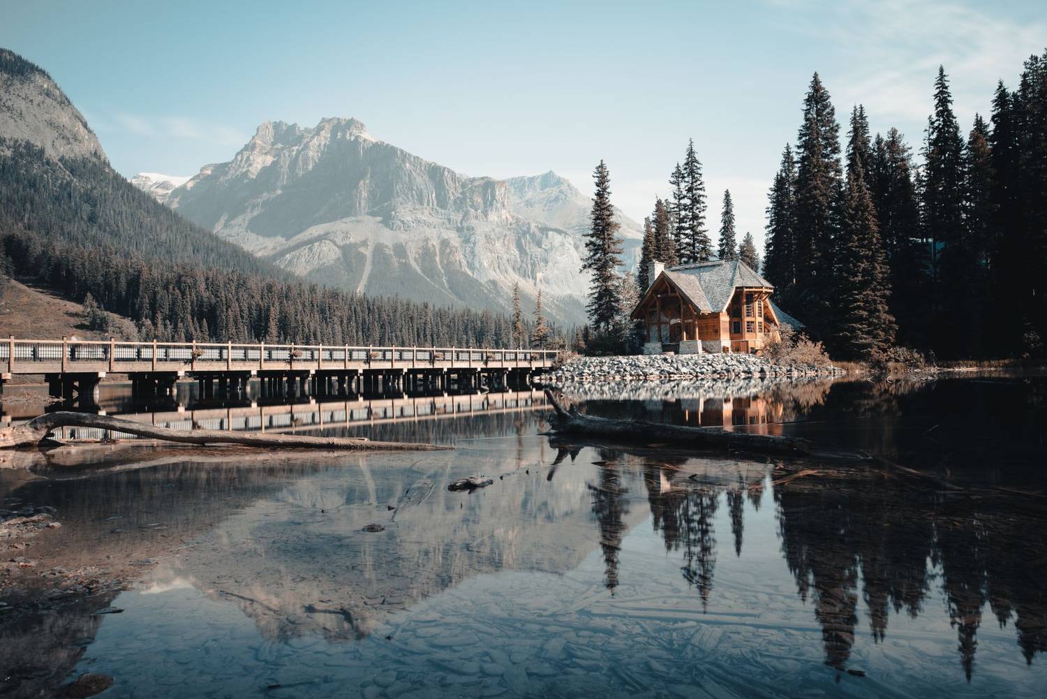 Beautiful lodge with bridge and mountains reflecting in Emerald Lake, BC.