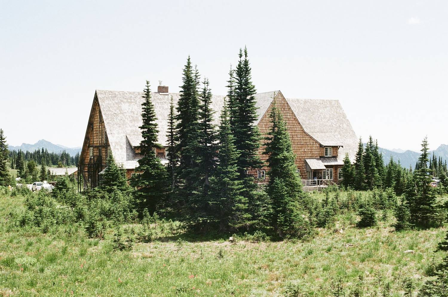A rustic lodge nestled amidst evergreen trees in a serene mountain setting.